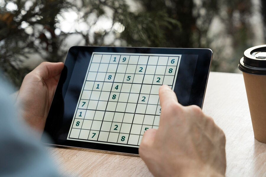 Person playing Sudoku on tablet